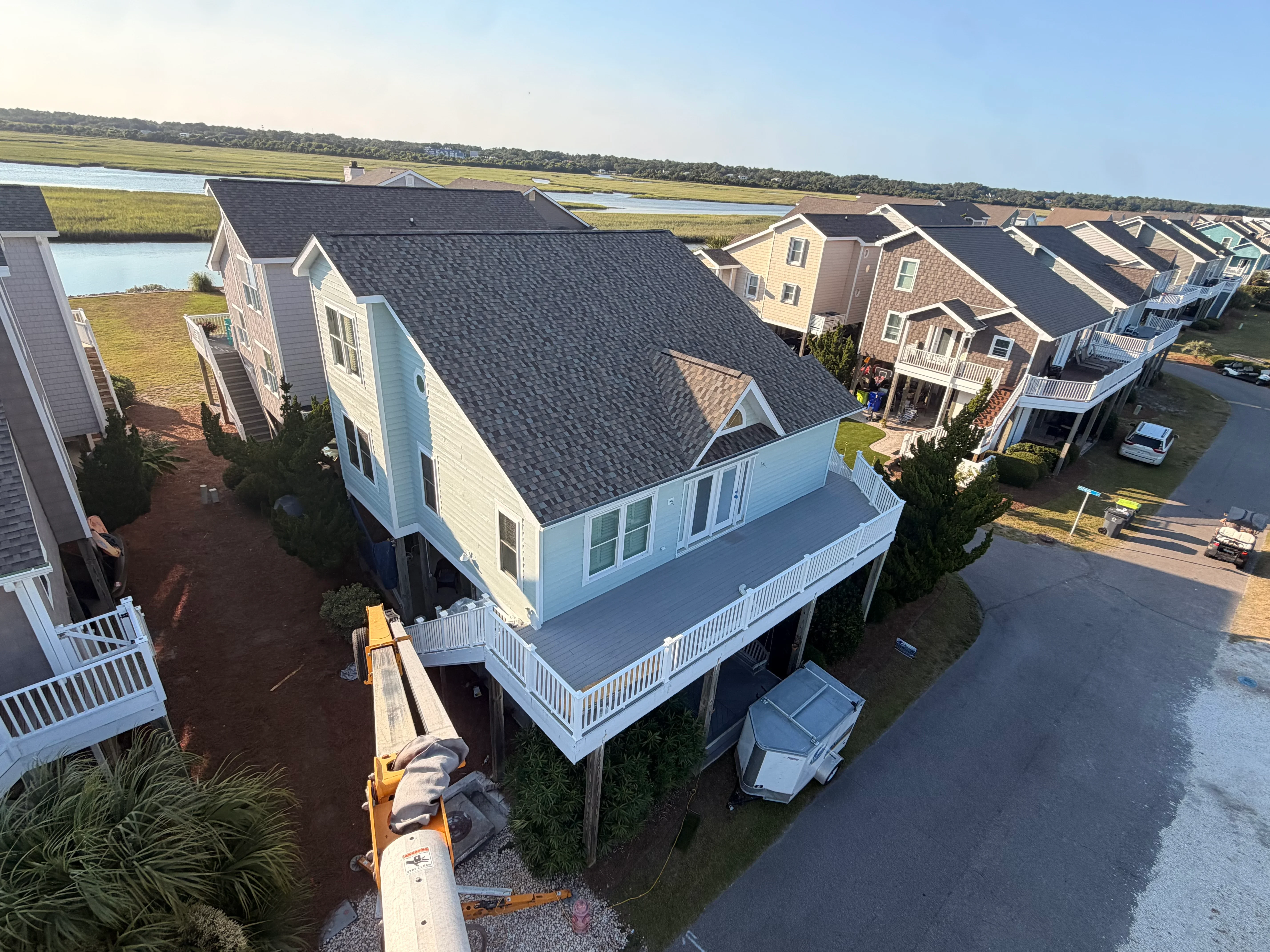 Elevated deck with white vinyl railing and composite decking on coastal home