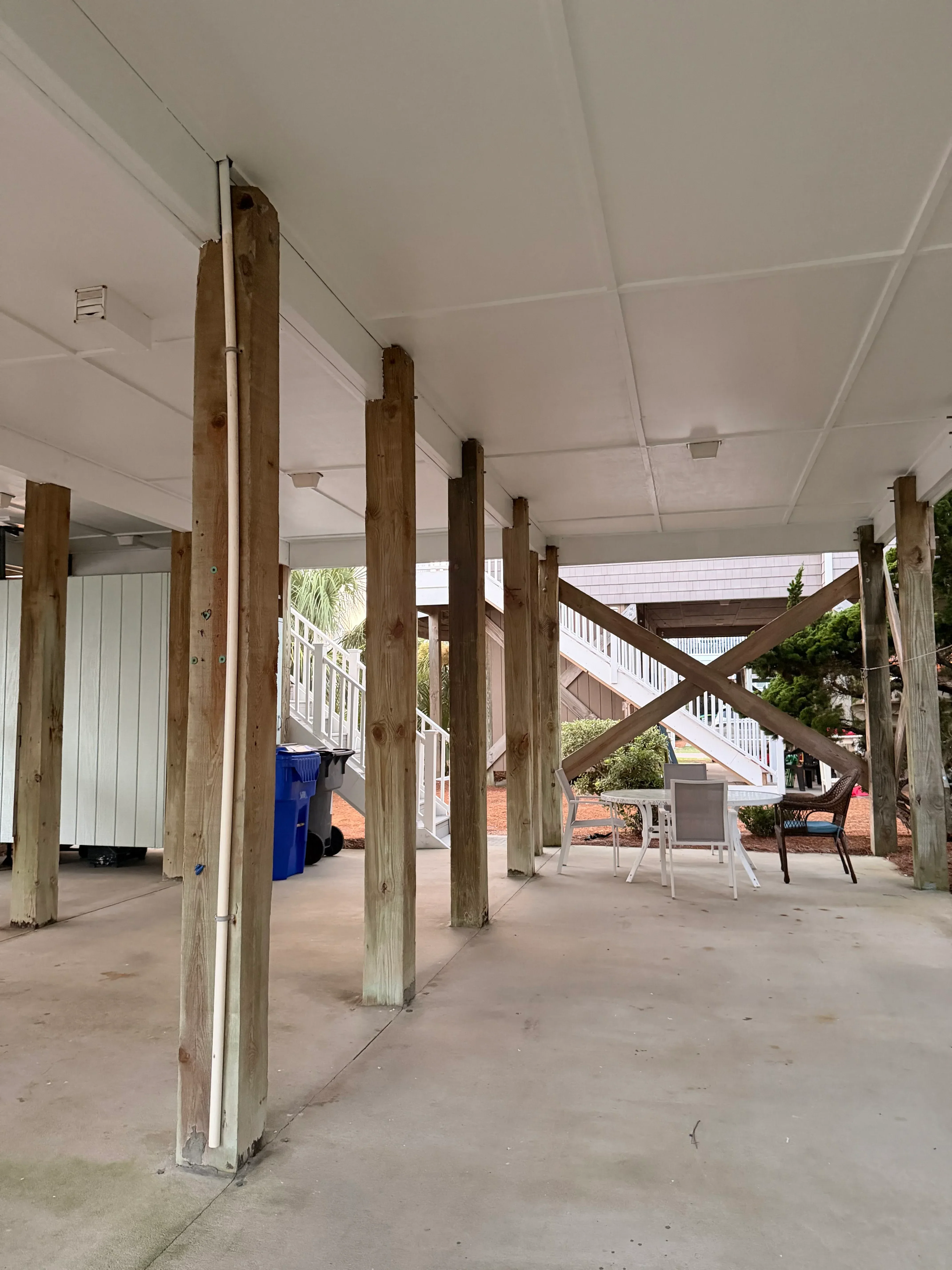 Pressure-treated wood deck framing with beams, joists, and X-pattern railing under construction