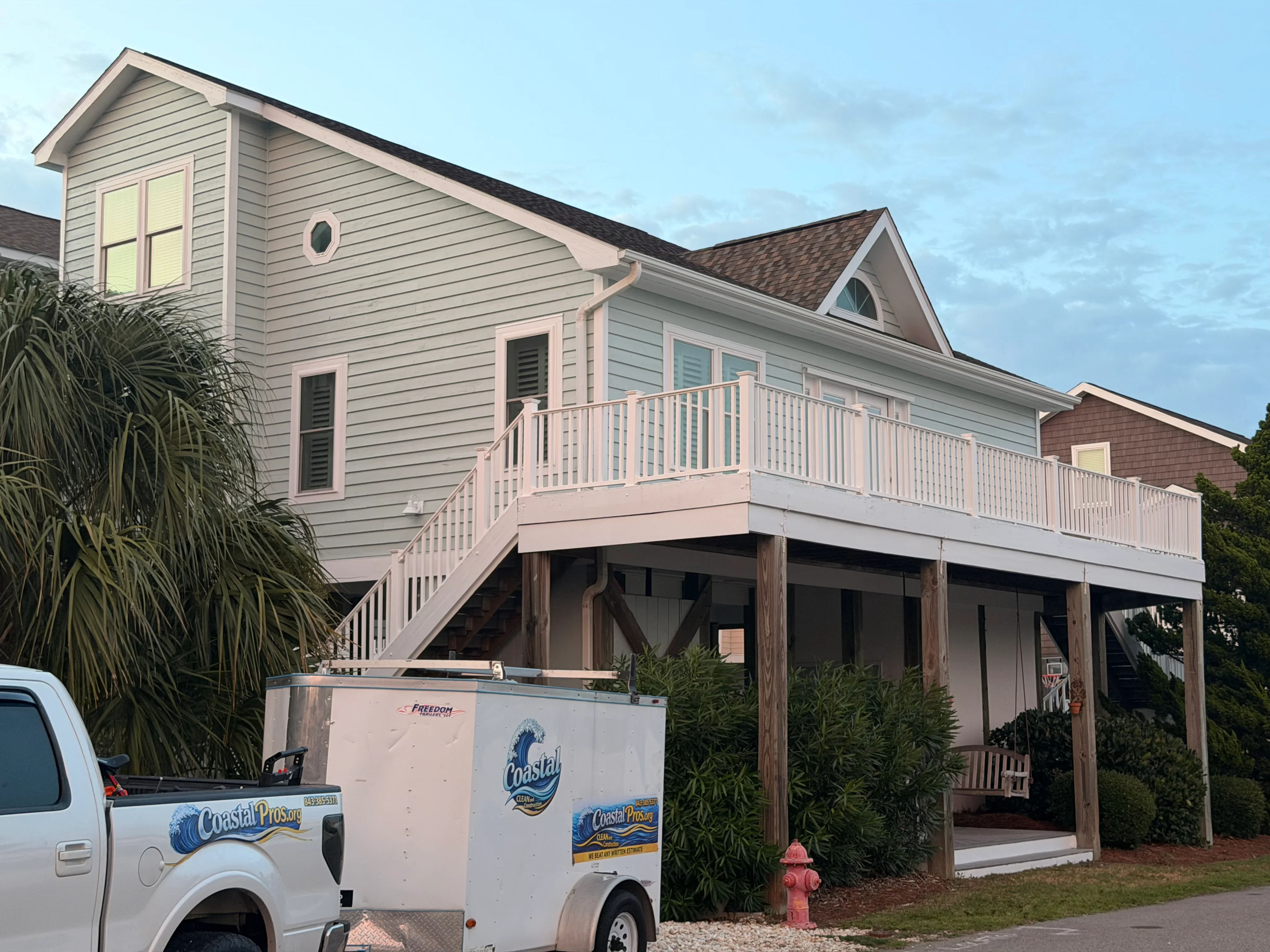 White vinyl deck railing and stairs on elevated wooden deck structure