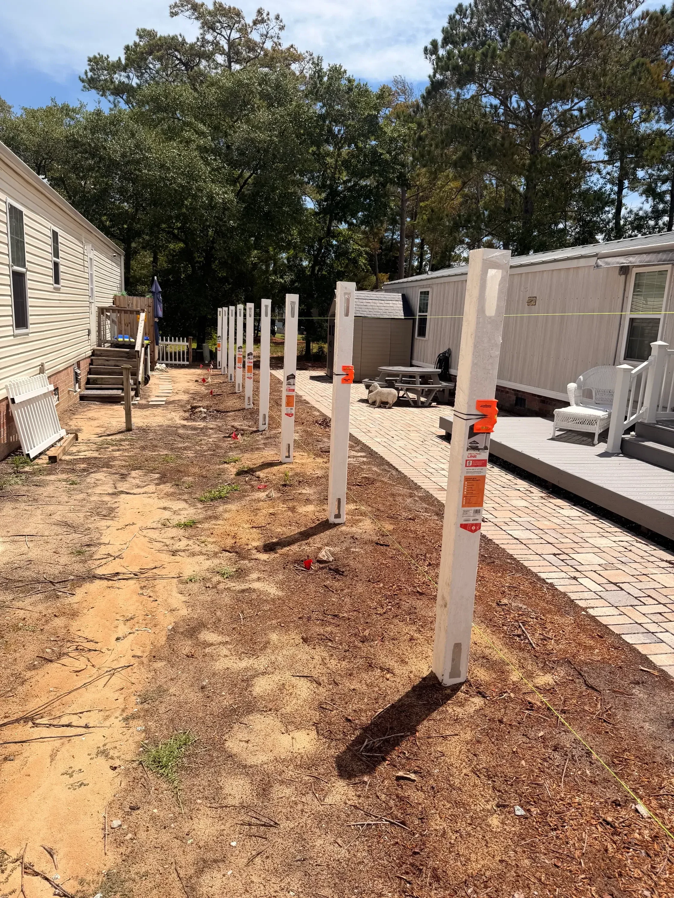 Wooden fence sections with levels and safety markers during residential installation