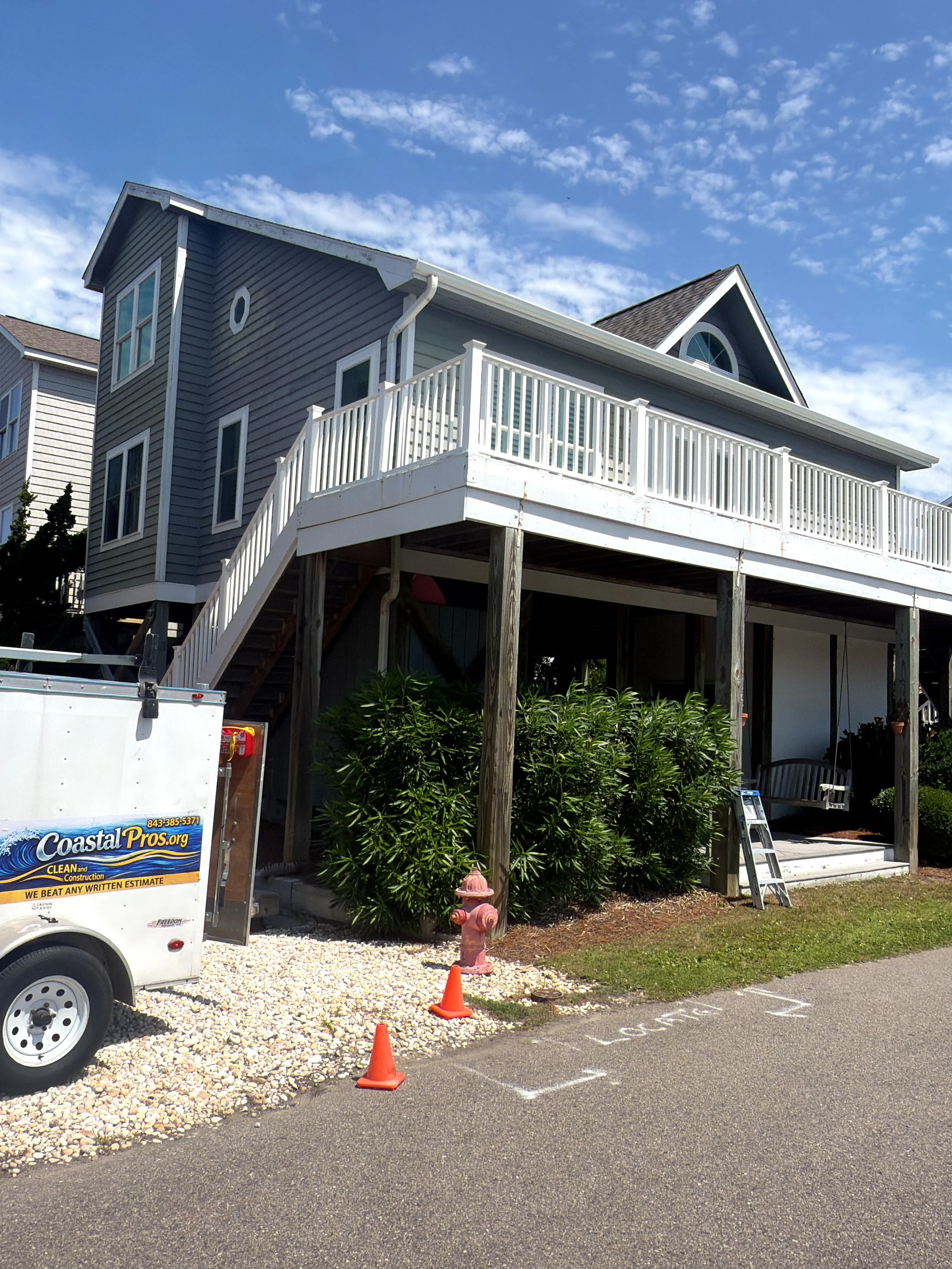 Elevated white vinyl deck railing with vertical balusters on residential home