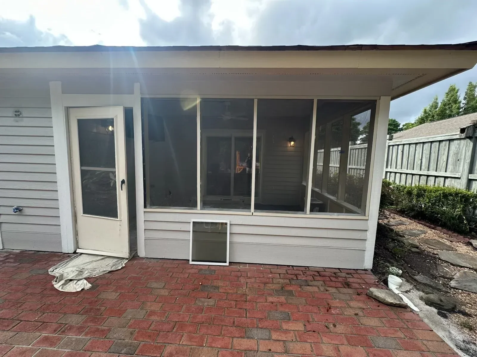 White vinyl picket fence with gate installed along residential property line